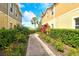Landscaped walkway showcasing lush greenery, palm trees, and colorful plants between buildings at 7979 Limestone Ln # 14-101, Sarasota, FL 34233