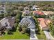 An aerial view showcases a house with a gray tiled roof amidst landscaped surroundings and neighboring houses at 826 Oak Briar Ln, Osprey, FL 34229