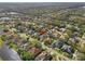 Aerial image of a neighborhood, marked with a locator, near a winding stream and lush vegetation at 826 Oak Briar Ln, Osprey, FL 34229