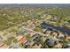 A wide aerial view shows residences near a winding water feature and the green expanse of a golf course at 826 Oak Briar Ln, Osprey, FL 34229