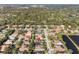 Scenic aerial view of a residential neighborhood featuring well-maintained homes, lush trees, and a nearby pond at 826 Oak Briar Ln, Osprey, FL 34229