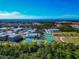 Aerial view of a school complex with tennis courts, buildings, and a distant view of the ocean at 826 Oak Briar Ln, Osprey, FL 34229