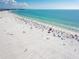 Aerial view of a crowded beach with white sand and clear turquoise water, perfect for relaxation and recreation at 826 Oak Briar Ln, Osprey, FL 34229