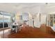 Bright dining room features a modern table, stylish chairs, and an artistic light fixture on sleek hardwood floors at 826 Oak Briar Ln, Osprey, FL 34229