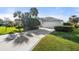 Beautiful single-story home featuring a well-manicured lawn and a spacious driveway leading to a two-car garage at 826 Oak Briar Ln, Osprey, FL 34229