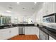 Well-equipped kitchen features stainless steel appliances, black countertops, and white cabinetry at 826 Oak Briar Ln, Osprey, FL 34229