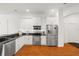 Modern kitchen featuring white cabinets, stainless steel appliances, and a sleek black countertop at 826 Oak Briar Ln, Osprey, FL 34229