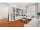 Bright living room includes hardwood floors, shutters, modern furniture, and a built-in bookshelf at 826 Oak Briar Ln, Osprey, FL 34229