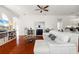 Open-concept living room featuring a white sectional sofa, a fireplace, and seamless transition to the kitchen at 826 Oak Briar Ln, Osprey, FL 34229