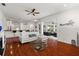Bright living room boasts hardwood floors, modern decor, and open floor plan with access to the kitchen and outdoor living space at 826 Oak Briar Ln, Osprey, FL 34229