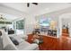 Bright living room boasts hardwood floors, modern decor, and access to the screened in outdoor pool area at 826 Oak Briar Ln, Osprey, FL 34229