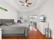 Bright primary bedroom features a tray ceiling, a ceiling fan, and wood-look floors at 826 Oak Briar Ln, Osprey, FL 34229