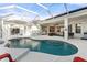 Stunning screened-in pool with ample seating, outdoor kitchen, and seamless transition to indoor living space at 826 Oak Briar Ln, Osprey, FL 34229