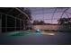 Enchanting screened-in pool area illuminated at twilight with an inviting pool and outdoor lights at 826 Oak Briar Ln, Osprey, FL 34229