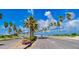 Scenic road lined with palm trees under a bright blue sky, offering a tropical and inviting atmosphere at 826 Oak Briar Ln, Osprey, FL 34229
