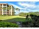 Building with well-maintained lawn and palm trees, offering a serene view at 8779 Midnight Pass Rd # 106H, Sarasota, FL 34242