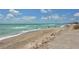 Beautiful beach scene with calm waters, blue skies and people enjoying the sand at 8779 Midnight Pass Rd # 106H, Sarasota, FL 34242