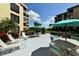 Outdoor community courtyard with tables, umbrellas and gas grills for residents at 8779 Midnight Pass Rd # 106H, Sarasota, FL 34242