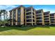 Landscaped condominium building surrounded by lawn at 8779 Midnight Pass Rd # 106H, Sarasota, FL 34242