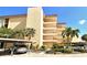 Beautiful condominium exterior featuring palm trees and covered parking spots for residents at 8779 Midnight Pass Rd # 106H, Sarasota, FL 34242