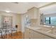 Bright kitchen featuring white cabinets and a cozy dining area with views into the living space at 8779 Midnight Pass Rd # 106H, Sarasota, FL 34242