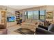Bright living room with large windows, comfortable furniture, and built-in shelving at 8779 Midnight Pass Rd # 106H, Sarasota, FL 34242