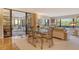 Open-concept living and dining area with sliding glass doors to a sunroom and views of the outdoors at 8779 Midnight Pass Rd # 106H, Sarasota, FL 34242