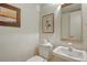 Powder room featuring traditional vanity, commode, framed art, and a neutral color scheme at 8779 Midnight Pass Rd # 106H, Sarasota, FL 34242