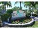 Eye-catching community sign with vibrant flowers and landscaping at 8779 Midnight Pass Rd # 106H, Sarasota, FL 34242