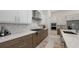 Well-equipped kitchen with stainless steel appliances, two-tone cabinetry, and a marble backsplash for a modern look at 8982 Baroque Ter, Sarasota, FL 34240