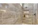 Close-up of shower showcasing tiled walls, recessed shelving, and modern fixtures, creating a luxurious spa-like environment at 8982 Baroque Ter, Sarasota, FL 34240