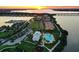 Stunning aerial view of waterfront community with sunset, marina, pool, and well-manicured landscaping at 910 Tidewater Shores Loop # 107, Bradenton, FL 34208
