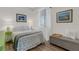 Cozy bedroom showcasing a decorative bed, a beach-themed pillow, and natural light from the window at 910 Tidewater Shores Loop # 107, Bradenton, FL 34208