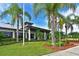 Exterior shot of the community clubhouse surrounded by landscaping and palm trees at 910 Tidewater Shores Loop # 107, Bradenton, FL 34208
