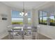 Dining area with a gray table, six white chairs, and windows offering a picturesque view of the water at 910 Tidewater Shores Loop # 107, Bradenton, FL 34208