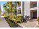 Exterior view of the building showing palm trees and manicured landscaping at 910 Tidewater Shores Loop # 107, Bradenton, FL 34208