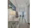 Long hallway featuring an entryway with an Anna Maria sign, decor, and views of the living area at 910 Tidewater Shores Loop # 107, Bradenton, FL 34208