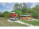 Kayaks are stored on wood racks along a path near mature tropical landscaping at 910 Tidewater Shores Loop # 107, Bradenton, FL 34208