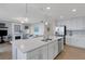 Open-concept kitchen with quartz countertops, stainless steel appliances, and view of the living room at 910 Tidewater Shores Loop # 107, Bradenton, FL 34208