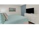Cozy main bedroom with coastal decor, white furniture, and television at 910 Tidewater Shores Loop # 107, Bradenton, FL 34208