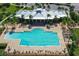 Aerial view of the pool and clubhouse surrounded by palm trees and ample seating at 910 Tidewater Shores Loop # 107, Bradenton, FL 34208
