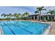 Inviting pool with clear blue water, palm trees, and comfortable lounge chairs at 910 Tidewater Shores Loop # 107, Bradenton, FL 34208