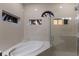Modern bathroom featuring a soaking tub and glass-enclosed shower with stylish tile surround and accent windows at 9408 Glen Abbey Ln, Sarasota, FL 34238