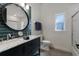 Modern bathroom with a double sink vanity, stylish round mirror, and a separate shower and toilet area at 9408 Glen Abbey Ln, Sarasota, FL 34238