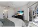Well-lit bedroom with a TV, access to the lanai, and desk space, creating a comfortable and functional living space at 9408 Glen Abbey Ln, Sarasota, FL 34238