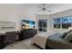 Cozy bedroom with a TV, desk, and a view of palm trees at sunset for a relaxed and inviting atmosphere at 9408 Glen Abbey Ln, Sarasota, FL 34238