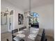 Well-lit dining room with a modern chandelier, a decorative painting, and a large window at 9408 Glen Abbey Ln, Sarasota, FL 34238