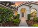 Inviting front entrance with decorative landscaping and charming arched windows at 9408 Glen Abbey Ln, Sarasota, FL 34238