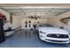 Well-organized two-car garage featuring epoxy flooring, ample storage, and a white sports car at 9408 Glen Abbey Ln, Sarasota, FL 34238
