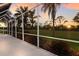 Outdoor lanai providing a view of the golf course, palm trees, and a beautiful sunset at 9408 Glen Abbey Ln, Sarasota, FL 34238
